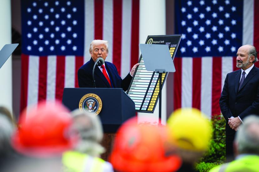 US President Donald Trump holding up a card of import tariffs